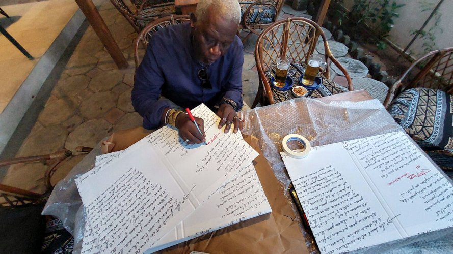 Georges Adéagbo signiert die Vorzugsausgabe seines Katalogs, Cotonou, 8. Dezember 2022
